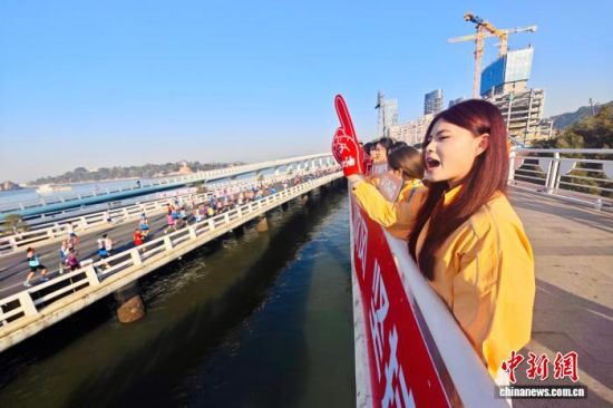 图为民众在赛道旁为选手加油助威。中新社记者 王东明 摄