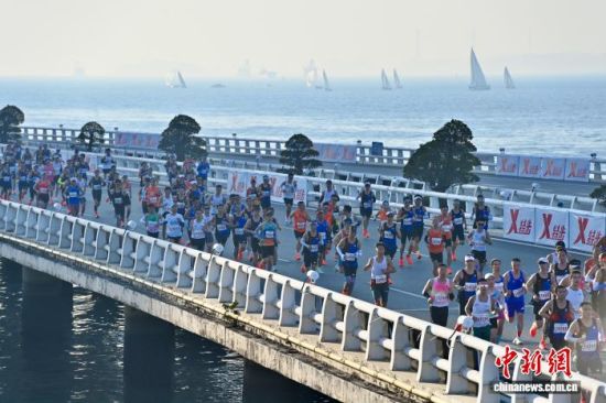 图为选手奔跑在美丽的海边赛道上。中新社记者 王东明 摄