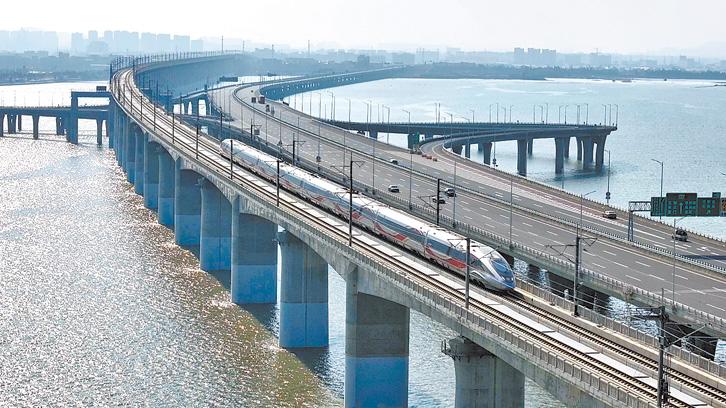 跨海大桥上 高铁与汽车“赛跑” 网友感叹：好可爱的春运图景