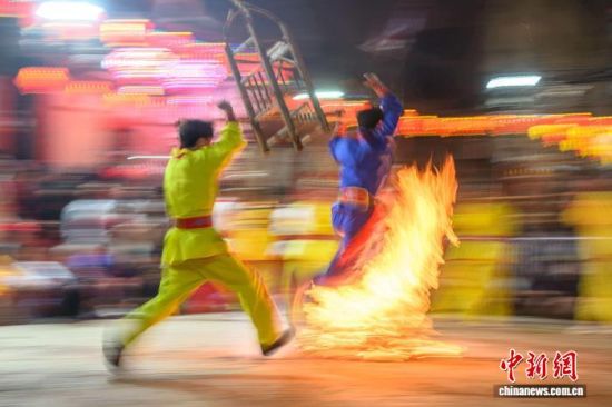 2月21日晚，福建省莆田市蒲坂村民众举行摆棕轿跳火闹元宵活动。蒲坂村摆棕轿跳火闹元宵传承至今已有500多年历史，火光呐喊声中寄托着人们对新年的美好期盼。图为民众摆棕轿跳火。中新社发 蔡昊 摄