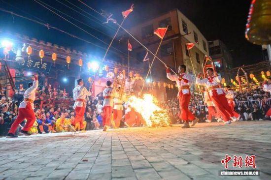 2月21日晚，福建省莆田市蒲坂村民众举行摆棕轿跳火闹元宵活动。蒲坂村摆棕轿跳火闹元宵传承至今已有500多年历史，火光呐喊声中寄托着人们对新年的美好期盼。图为民众摆棕轿跳火。中新社发 蔡昊 摄