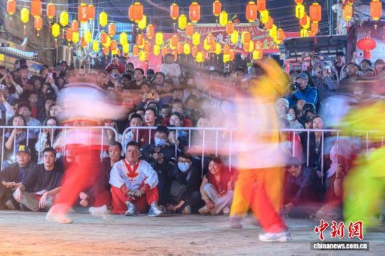 2月21日晚，福建省莆田市蒲坂村民众举行摆棕轿跳火闹元宵活动。蒲坂村摆棕轿跳火闹元宵传承至今已有500多年历史，火光呐喊声中寄托着人们对新年的美好期盼。图为活动吸引许多市民和游客围观。中新社发 蔡昊 摄