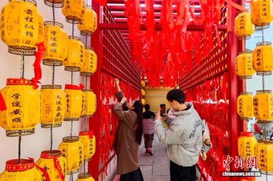 图为游客在螺洲孔庙挂牌祈福。中新社记者 王东明 摄 图为游客在螺洲孔庙挂牌祈福。中新社记者 王东明 摄