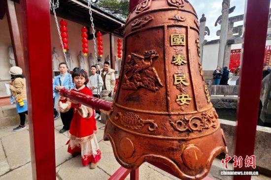 图为游客在螺洲孔庙撞钟祈福。中新社记者 王东明 摄 图为游客在螺洲孔庙撞钟祈福。中新社记者 王东明 摄