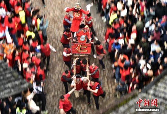 图为村民们抬着“古事”在村庄里狂奔。中新社记者 张斌 摄