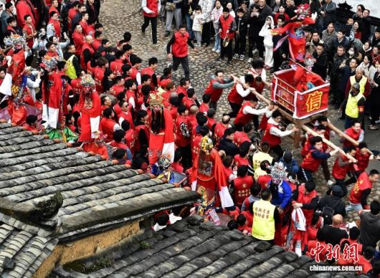 图为村民们抬着“古事”在村庄里狂奔。中新社记者 张斌 摄