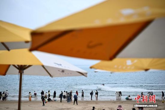 4月11日，游客在平潭坛南湾景区沙滩上游玩。中新社记者 张斌 摄