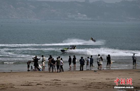 4月11日，游客在平潭坛南湾景区乘坐海上摩托艇。中新社记者 张斌 摄